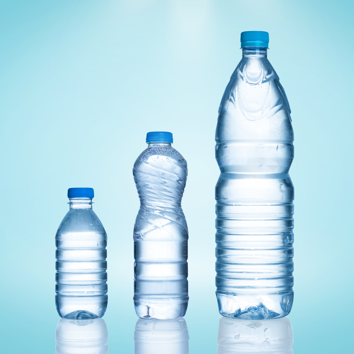 Assortment of water bottles in various sizes on a light blue background.